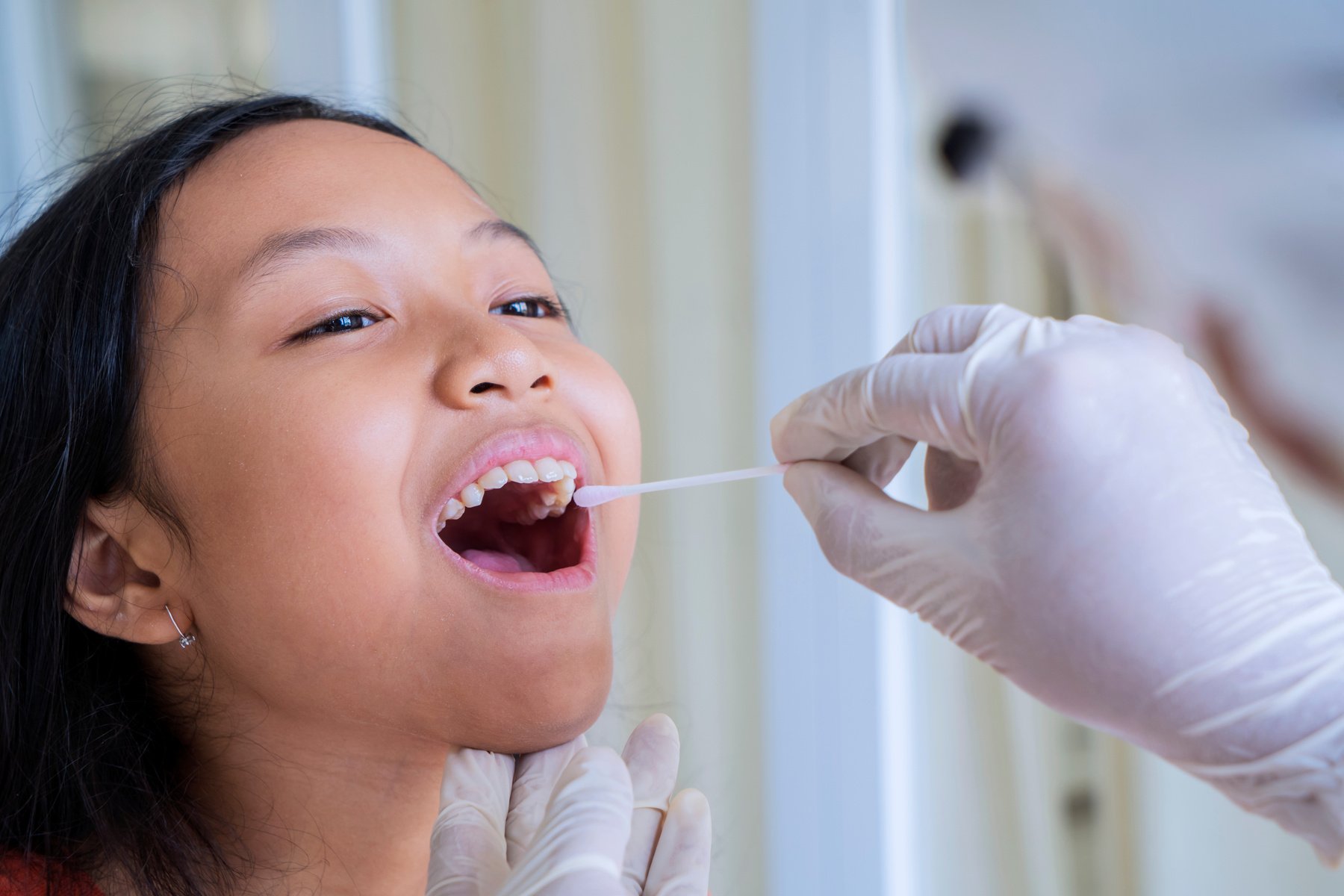 Hands with Gloves Collecting Buccal Swab Sample from Girl's Mouth